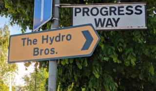 Ubicación de Hydro Bros en Progress Way, indicada por una señal de tráfico amarilla.