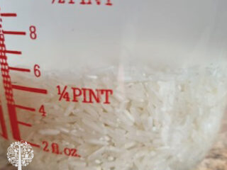 Strain cloudy water from soaked rice.