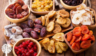 An assortment of dried fruits in wooden bowls.