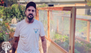 Fernandez stands in front of a raised garden bed at Victory Garden LA.