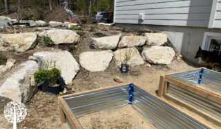 A garden area with rocks and a hardscape designed to create thermal mass.
